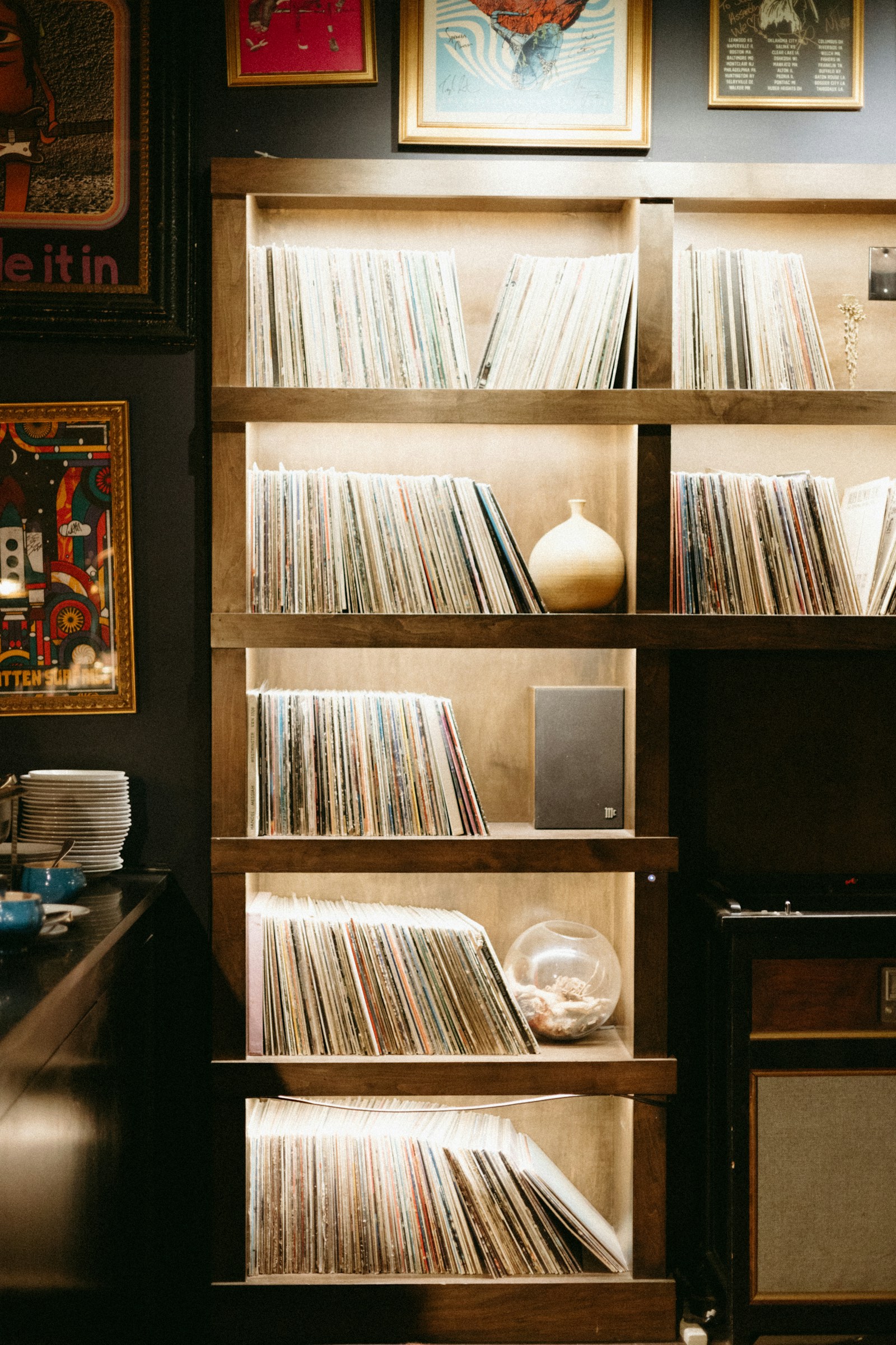 Wooden record library shelves filled with colourful vinyl sleeves